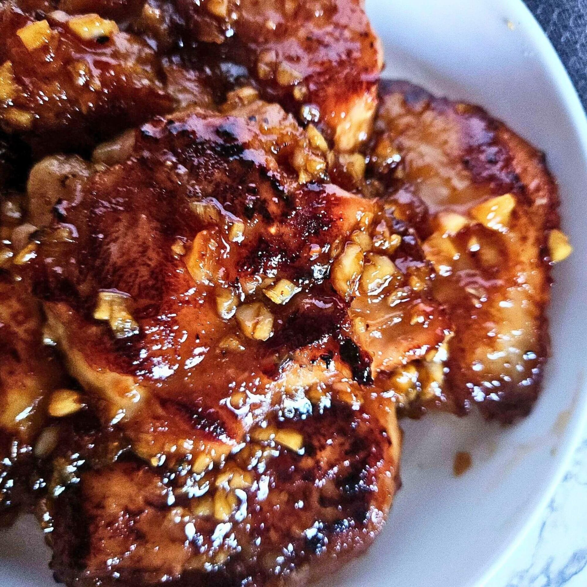 Close up picture of sticky honey garlic chicken thigs glazed with honey garlic sauce.