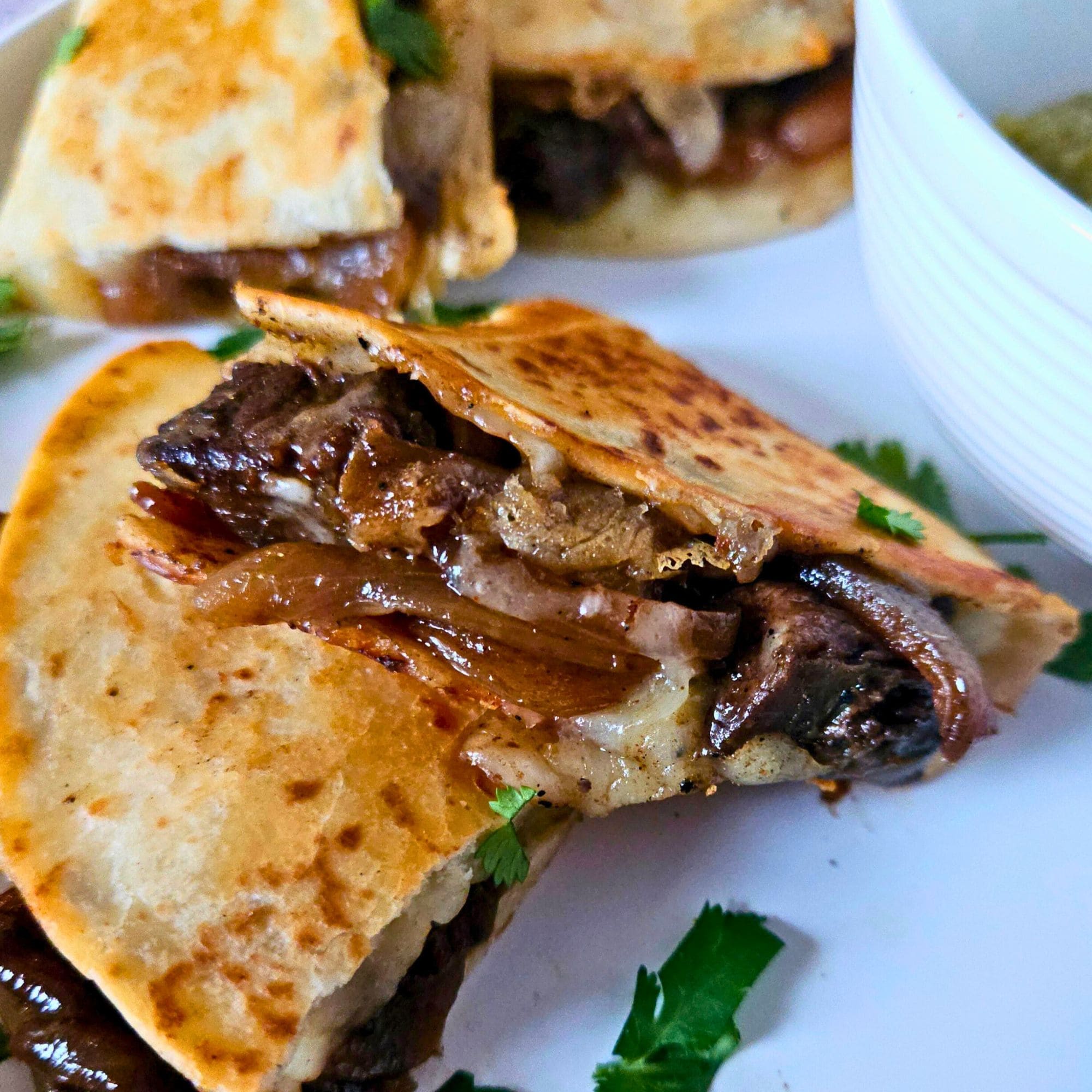 Flank steak quesadilla with sauteed onions and melted cheese.