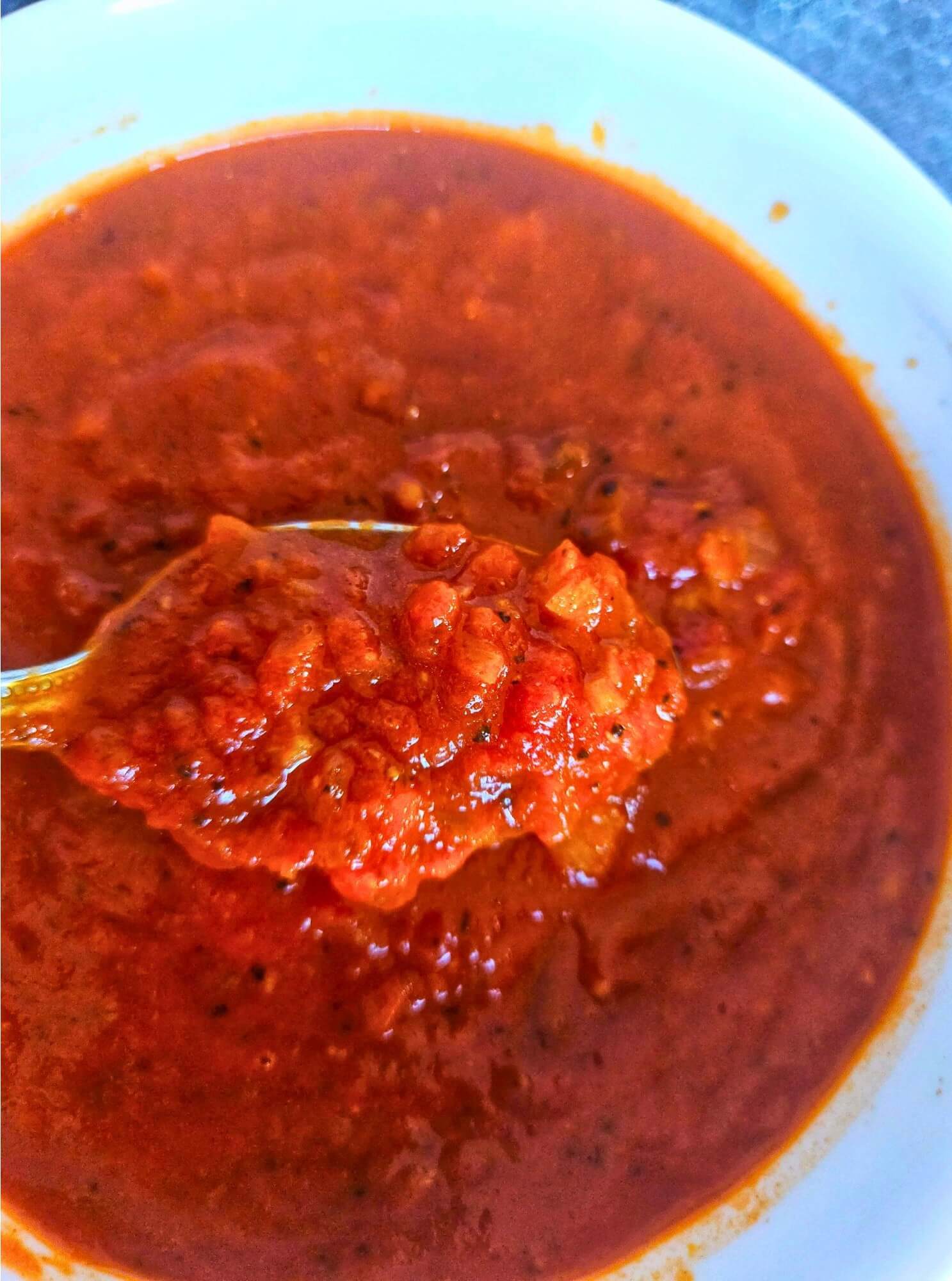 Image of Bravas sauce being scooped with a spoon.