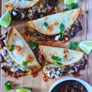 Crispy Barbacoa beef tacos with slow braised beef being served with salsa.