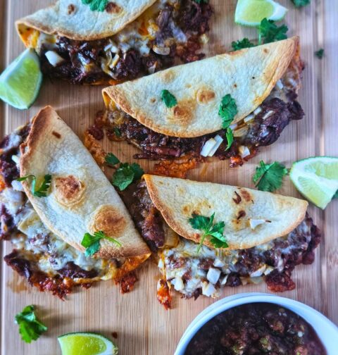 Crispy Barbacoa beef tacos with slow braised beef being served with salsa.