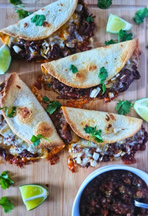 Crispy Barbacoa beef tacos with slow braised beef being served with salsa.