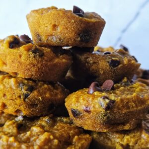 Close up image of gluten free pumpkin muffins stacked on a plate.