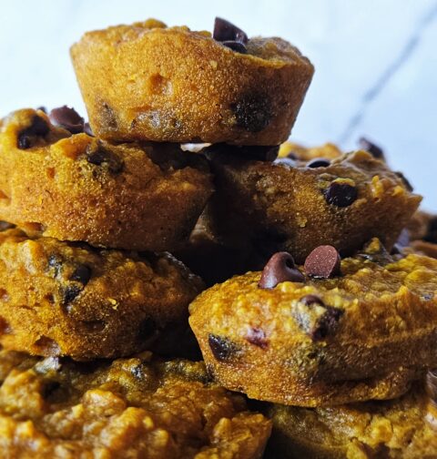 Close up image of gluten free pumpkin muffins stacked on a plate.