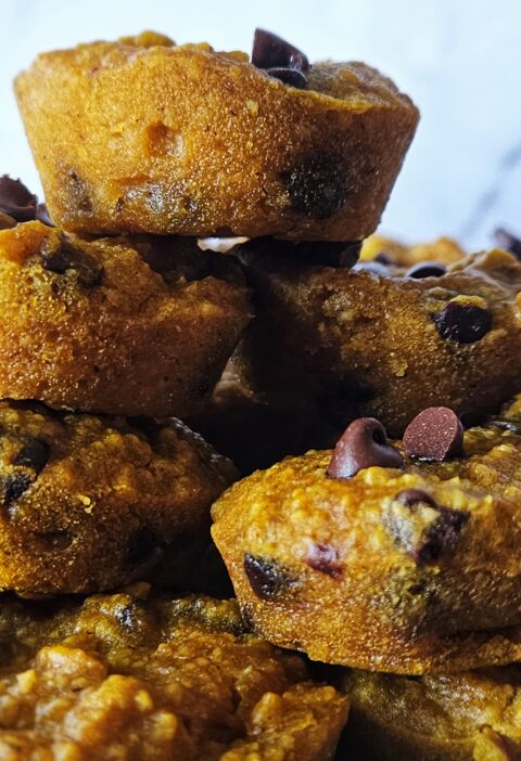 Close up image of gluten free pumpkin muffins stacked on a plate.