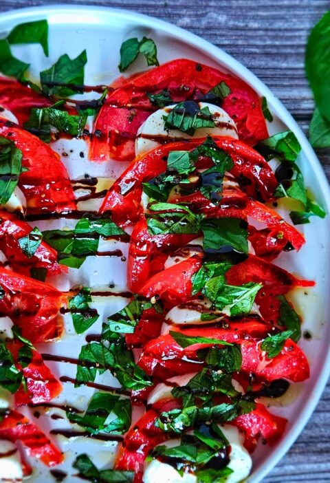 Image of Caprese Salad with fresh mozzarella, tomatoes, chopped basil and balsamic drizzle.