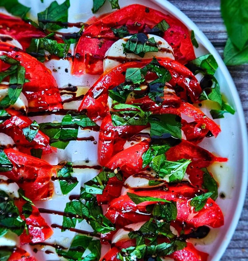 Image of Caprese Salad with fresh mozzarella, tomatoes, chopped basil and balsamic drizzle.
