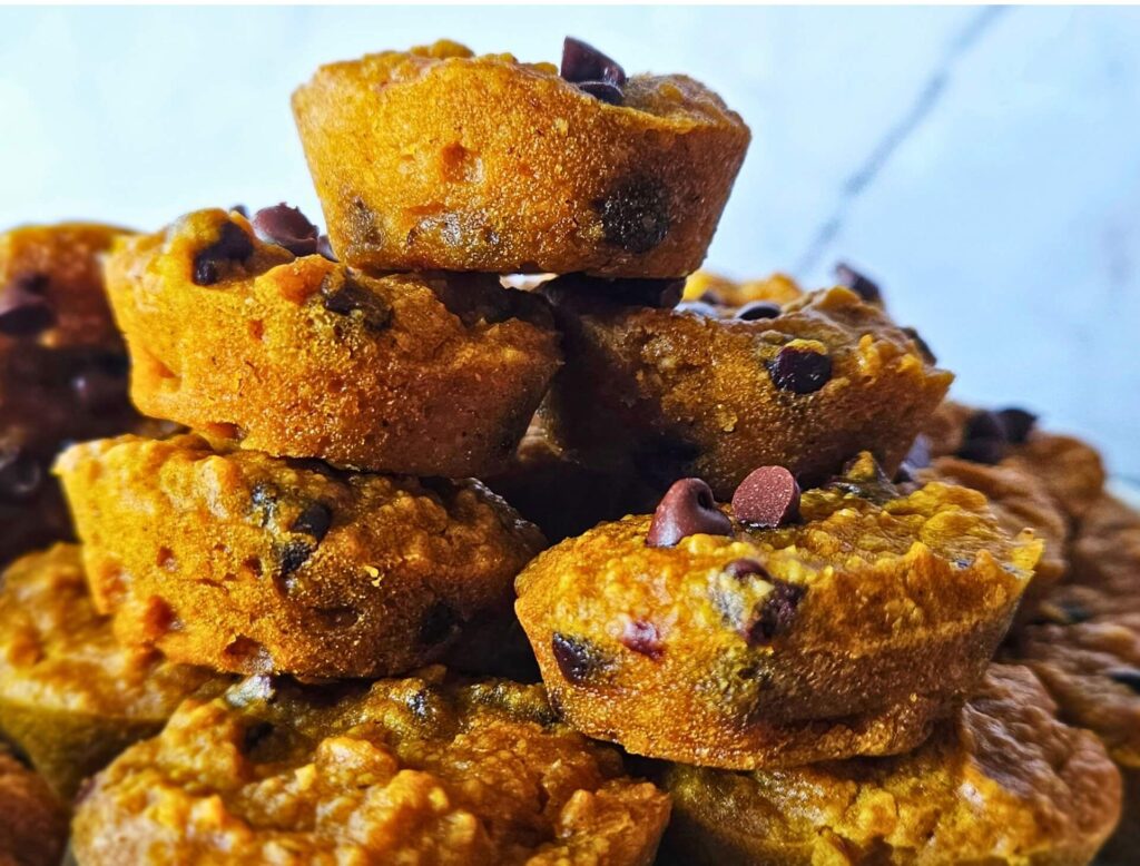 Close up image of gluten free pumpkin muffins stacked on a plate.
