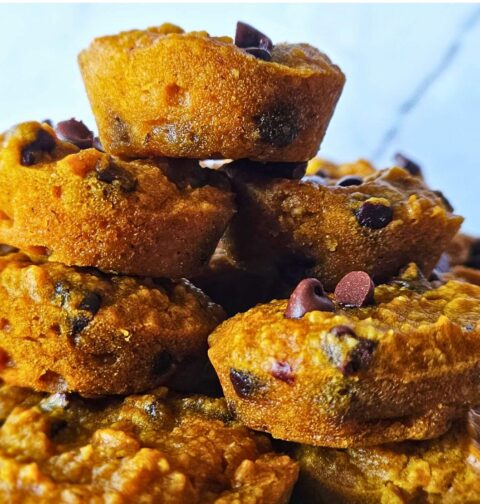 Close up image of gluten free pumpkin muffins stacked on a plate.