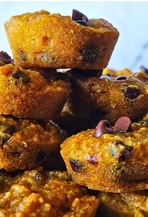 Close up image of gluten free pumpkin muffins stacked on a plate.
