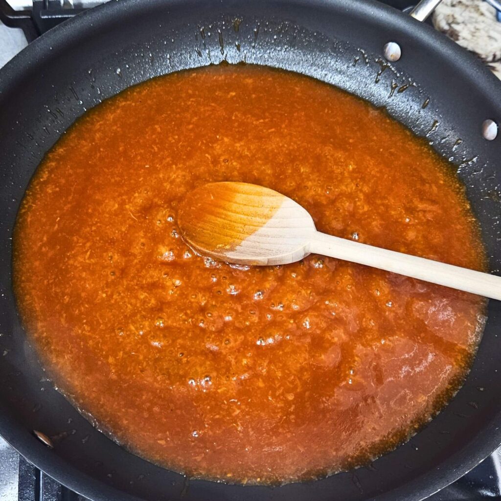 The gochujang sauce simmering in a skillet.
