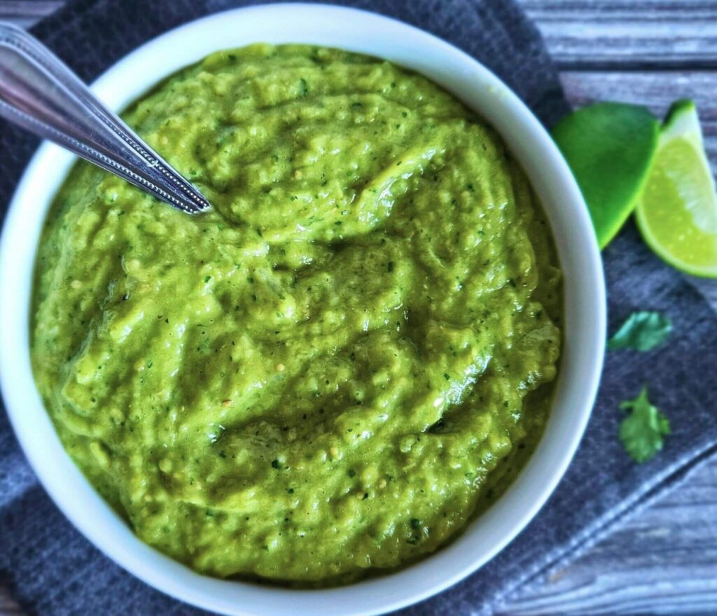Tomatillo Avocado Salsa 7 Image of easy tomatillo avocado salsa in a serving bowl with a spoon.