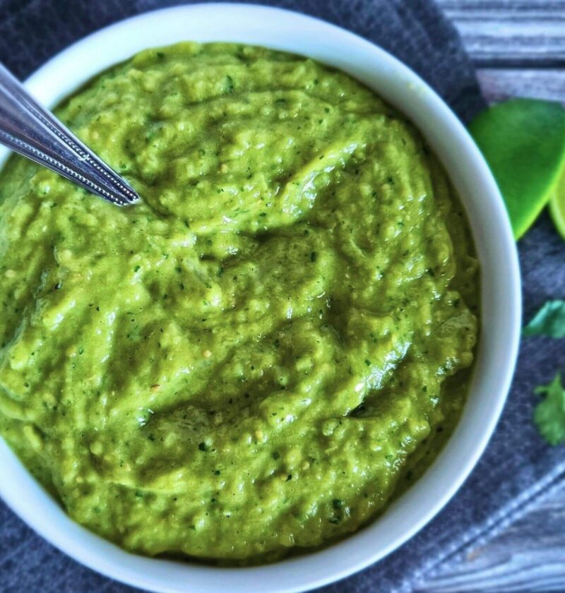 Image of easy tomatillo avocado salsa in a serving bowl with a spoon.