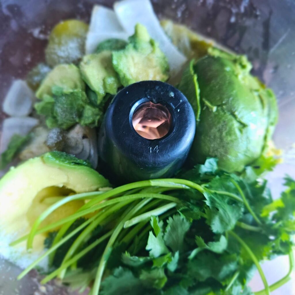 Tomatillo Avocado Salsa prep 1 Roasted veggies along with avocado, cilantro, lime juice and salt in the food processor to be blended into avocado tomatillo salsa.