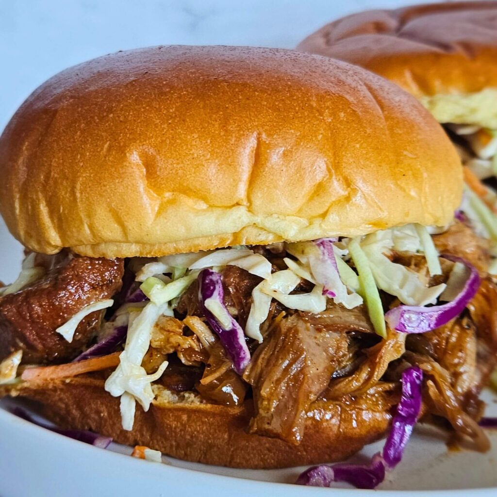 Closeup image of Dutch oven pulled pork sandwich with tangy coleslaw.