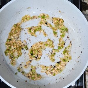 Sautéing garlic and white parts of green onion in the skillet. 