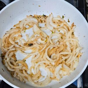 Sautéing the garlic, white parts of green onion and sweet onion in the skillet.  
