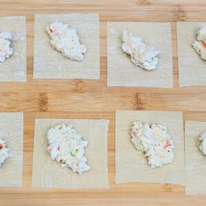 Step-by-step photo of how to make crab rangoons with cream cheese and crab filling.