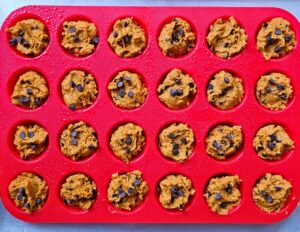 Protein pumpkin muffin batter spooned into the muffin pan before baking.