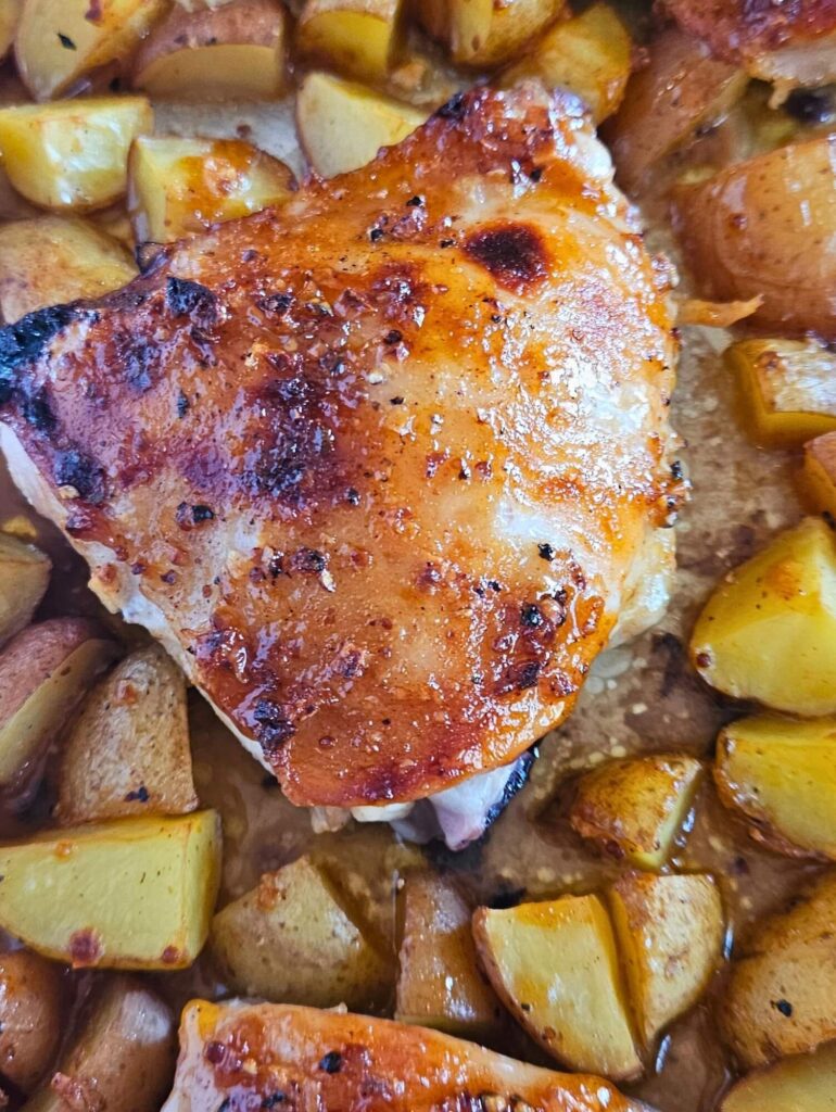 Sheet Pan Honey Mustard Chicken 17 Close up image of sheet pan honey mustard chicken thighs with roasted potatoes.