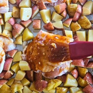 Chicken thighs being brushed with honey mustard sauce.