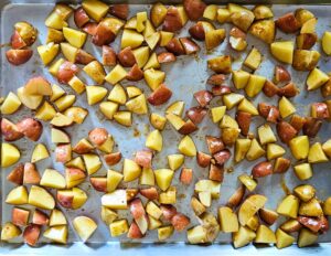 Potatoes on a sheet pan in an even layer before roasting.