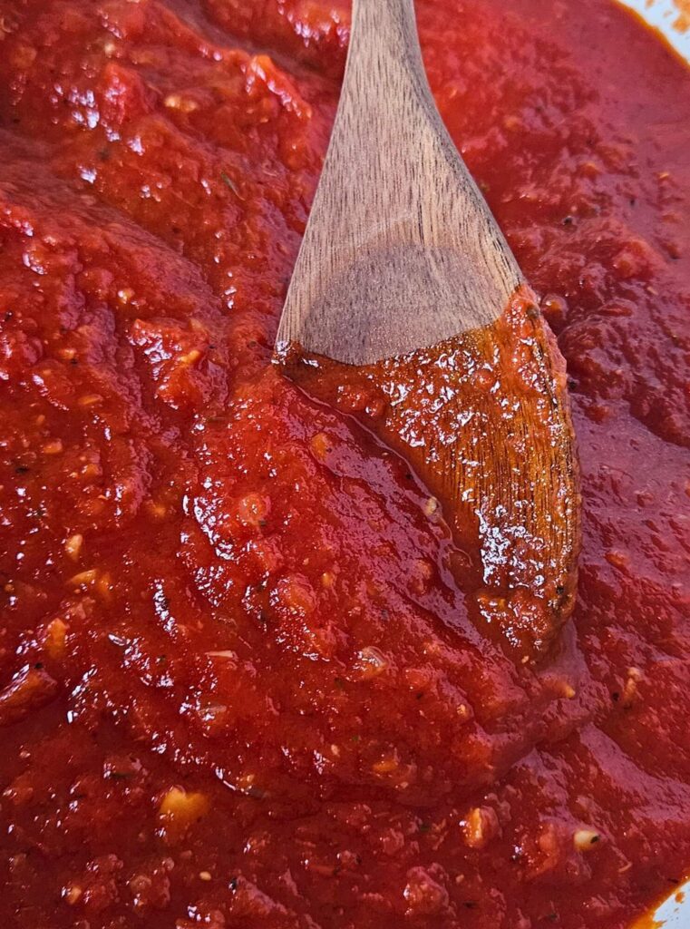 Marinara Sauce 4 Homemade marinara sauce being stirred while simmering.