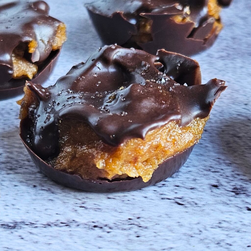 Close up image of dark chocolate covered pumpkin caramel bites.