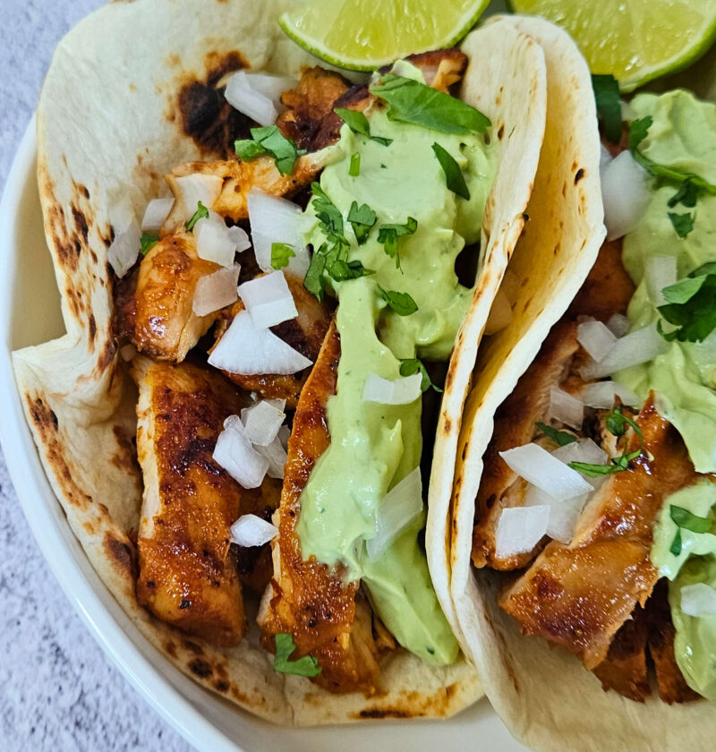 Close up image of chipotle chicken tacos with avocado crema.