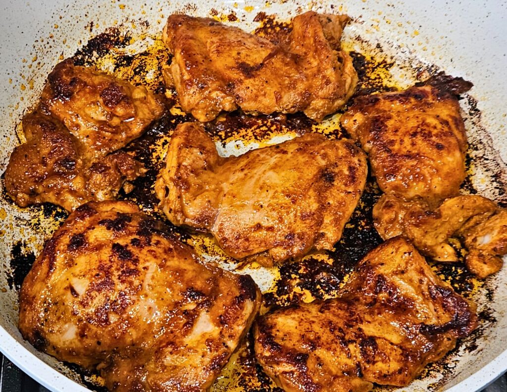 Maple Chipotle Chicken Tacos Prep 7 Image of maple chipotle chicken thighs being seared in a skillet.
