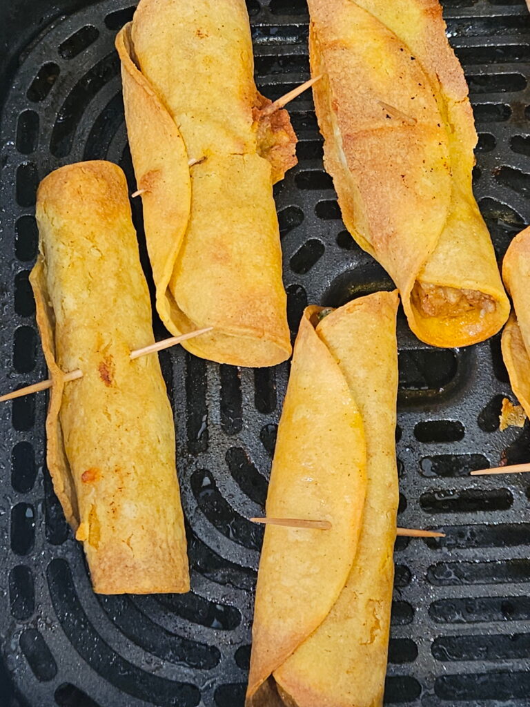 Image of cream cheese chicken taquitos in the air fryer. 