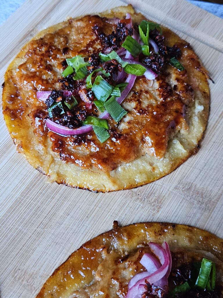 Image of sticky ground chicken smashed dumpling tacos being served on a cutting board.
