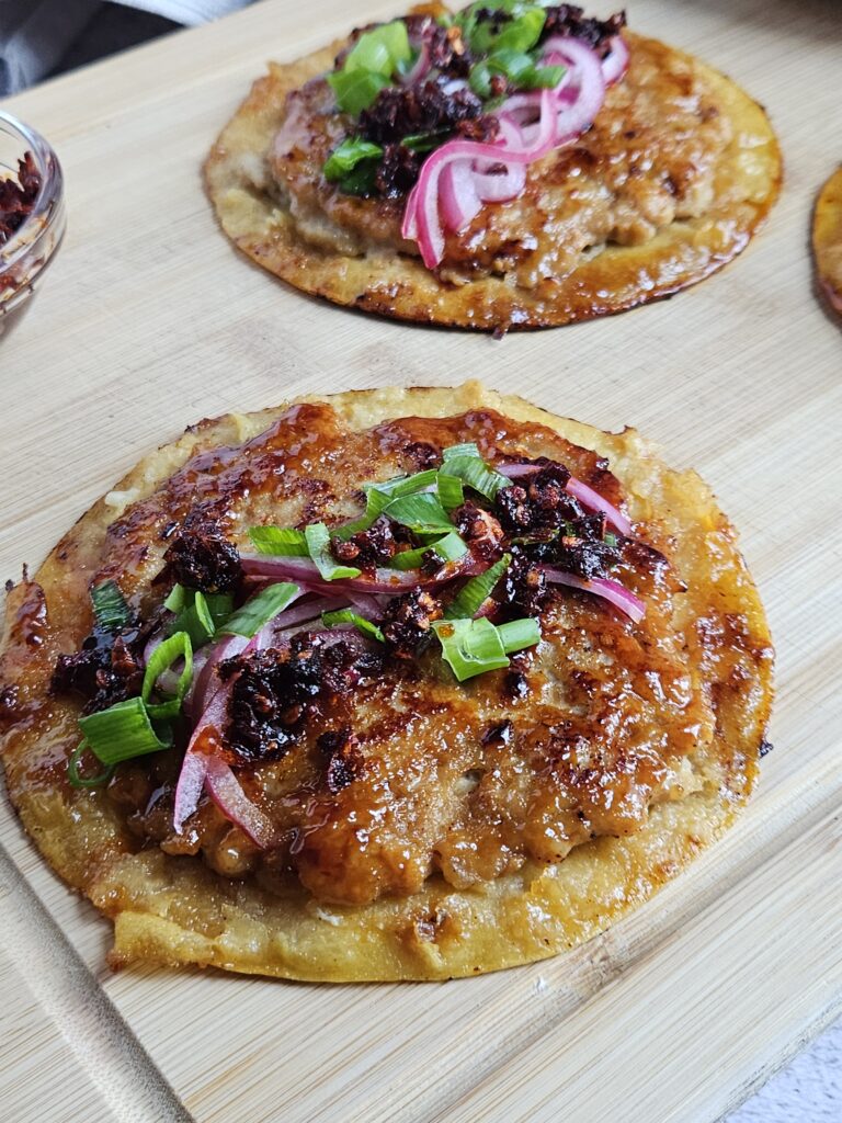 Image of sticky ground chicken smashed dumpling tacos being served on a cutting board.