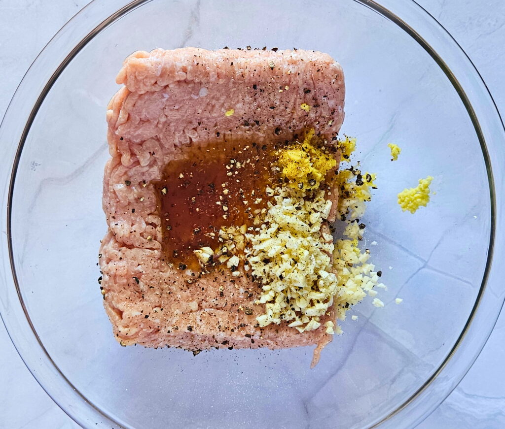 Image of ground chicken and other ingredients in a bowl for the smashed dumpling tacos.